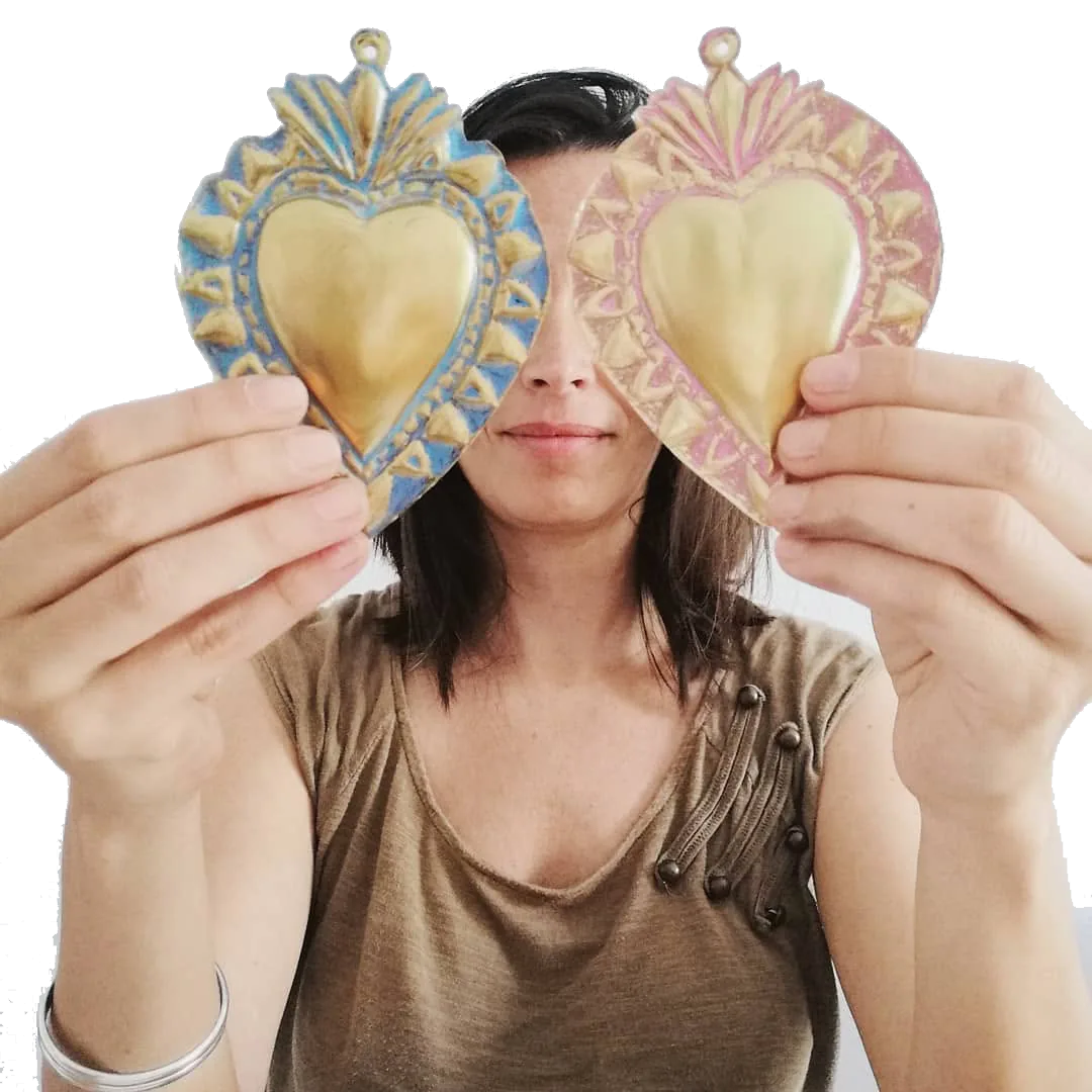Clara sosteniendo dos corazones repujados